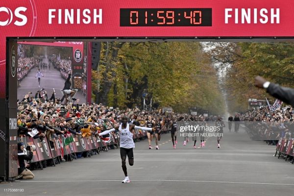 Kenya's Eliud Kipchoge (white jersey) celebrates as he crosses the finish line at the end of his attempt to bust the mythical two-hour barrier for the marathon on October 12 2019 in Vienna. PHOTO/ GETTY IMAGES