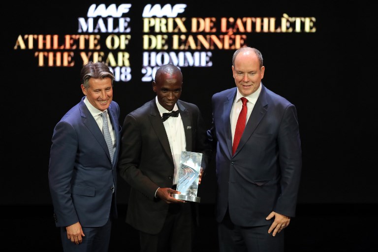 Kenyan athlete Eliud Kipchoge poses next to president of the International Association of Athletics Federations (IAAF) Sebastian Coe and Prince Albert II of Monaco after receing the Male athlete of the year award during the IAAF athlete of the year awards ceremony, on December 4, 2018 in Monaco.PHOTO/ AFP