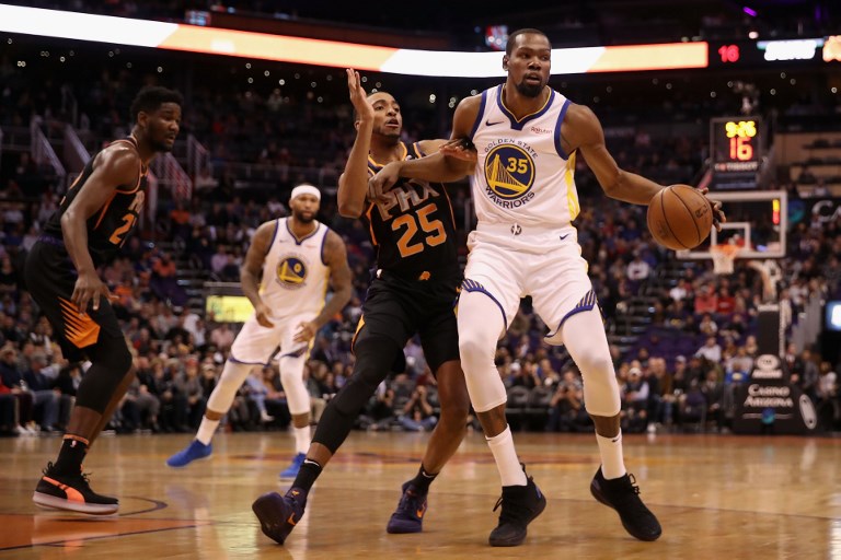 Kevin Durant (right) of the Golden State Warriors handles the ball against Mikal Bridges of the Phoenix Suns during the first half of the NBA game at Talking Stick Resort Arena on February 08, 2019 in Phoenix, Arizona. PHOTO/AFP
