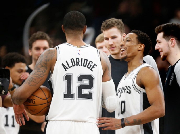 LaMarcus Aldridge #12 of the San Antonio Spurs is congratulated by his teammates after they defeated the Oklahoma City Thunder in double overtime at AT&T Center on January 10, 2019 in San Antonio, Texas. PHOTO/GettyImages