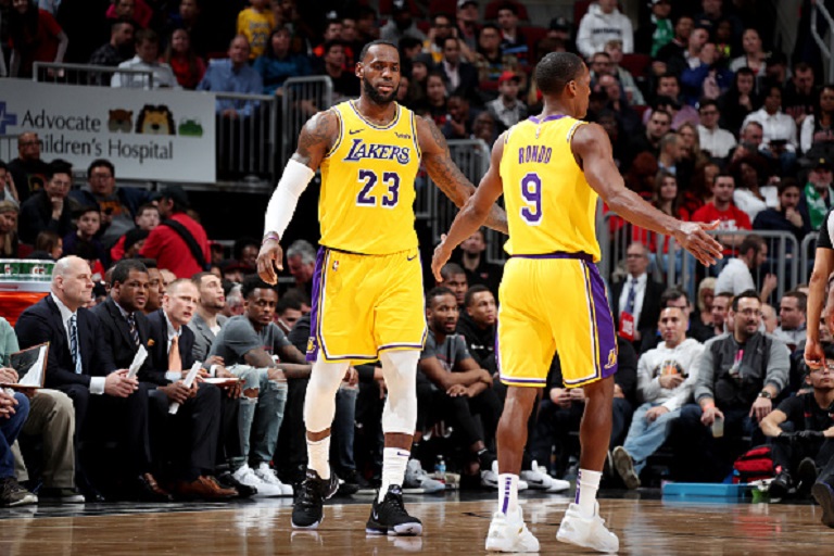 LeBron James #23 and Rajon Rondo #9 of the Los Angeles Lakers high five during the game against the Chicago Bulls on March 12, 2019 at the United Center in Chicago, Illinois. PHOTO/GettyImages