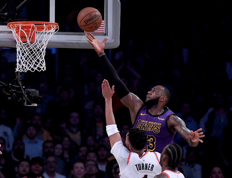 LeBron James #23 of the Los Angeles Lakers scores over Evan Turner #1 of the Portland Trail Blazers during a 126-117 Laker win at Staples Center on November 14, 2018 in Los Angeles, California.PHOTO/AFP