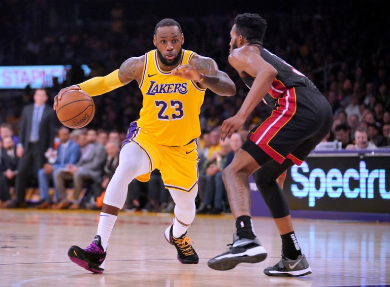 LeBron James (left) of the Los Angeles Lakers drives to the basket on Derrick Jones Jr. of the Miami Heat during a 108-105 Laker win at Staples Center on December 10, 2018 in Los Angeles, California. PHOTO/AFP