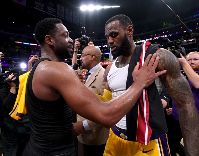 LeBron James (right) of the Los Angeles Lakers and Dwyane Wade of the Miami Heat talk after exchanging jerseys, in Wade's last regular season game visit to Staples Center, after a 108-105 Laker win at Staples Center on December 10, 2018 in Los Angeles, California. PHOTO/AFP
