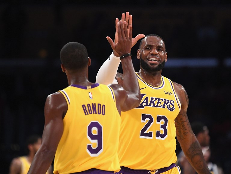 LeBron James (right) of the Los Angeles Lakers high fives Rajon Rondo during a preseason game against the Denver Nuggets at Staples Center on October 2, 2018 in Los Angeles, California. PHOTO/AFP