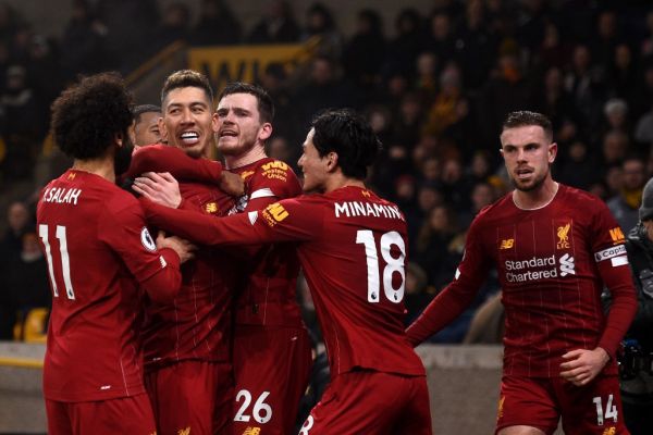 Liverpool's Brazilian midfielder Roberto Firmino (CL) celebrates with teammates after he scores the team's second goal during the English Premier League football match between Wolverhampton Wanderers and Liverpool at the Molineux stadium in Wolverhampton, central England on January 23, 2020. PHOTO | AFP