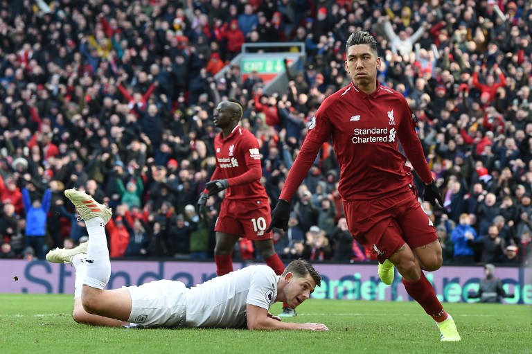 Liverpool's Brazilian midfielder Roberto Firmino (R) celebrates scoring their third goal during the English Premier League football match between Liverpool and Burnley at Anfield in Liverpool, north west England on March 10, 2019. PHOTO/AFP