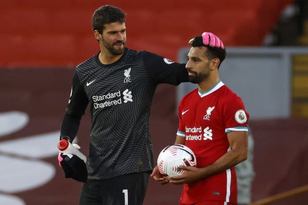 Liverpool's Egyptian midfielder Mohamed Salah takes the match ball as he walks off with Liverpool's Brazilian goalkeeper Alisson Becker after the English Premier League football match between Liverpool and Leeds United at Anfield in Liverpool, north west England on September 12, 2020. Liverpool won the game 4-3. PHOTO | AFP