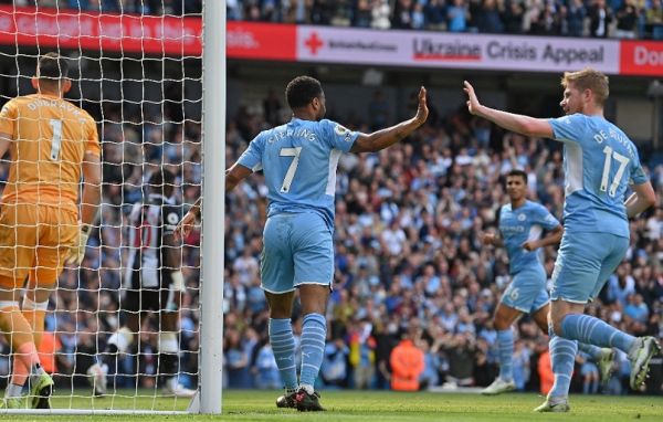 Manchester City's English midfielder Raheem Sterling (C) celebrates scoring the opening goal with Manchester City's Belgian midfielder Kevin De Bruyne during the English Premier League football match between Manchester City and Newcastle United at the Etihad Stadium in Manchester, north west England, on May 8, 2022. PHOTO | AFP