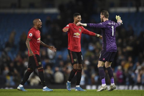 Manchester United's English defender Ashley Young, Manchester United's Spanish goalkeeper David de Gea and Manchester United's English striker Marcus Rashford celebrate victory at the end of the English Premier League football match between Manchester City and Manchester United at the Etihad Stadium in Manchester, north west England, on December 7, 2019. PHOTO \ AFP