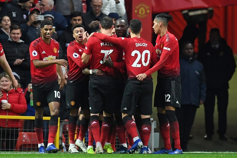 Manchester United's English midfielder Ashley Young celebrates with teammates after scoring the opening goal of the English Premier League football match between Manchester United and Fulham at Old Trafford in Manchester, north west England, on December 8, 2018.PHOTO/AFP