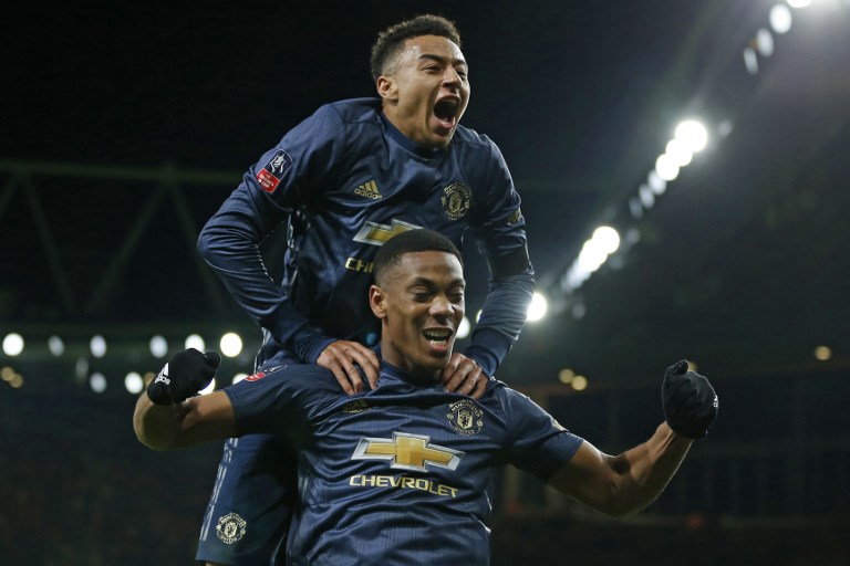 Manchester United's English midfielder Jesse Lingard celebrates by leaping onto the back of Manchester United's French striker Anthony Martial after Martial scores their third goal during the English FA Cup fourth round football match between Arsenal and Manchester United at the Emirates Stadium in London on January 25, 2019. PHOTO/AFP
