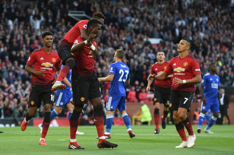 Manchester United's French midfielder Paul Pogba (C) with Manchester United's Brazilian midfielder Fred (2L) and Manchester United's Chilean striker Alexis Sanchez (R) after scoring the opening penalty during the English Premier League football match between Manchester United and Leicester City at Old Trafford in Manchester, north west England, on August 10, 2018. PHOTO/AFP