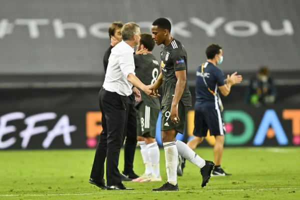 Manchester United's Norwegian manager Ole Gunnar Solskjaer (L) shakes hands with Manchester United's French striker Anthony Martial after the UEFA Europa League semi-final football match Sevilla v Manchester United on August 16, 2020 in Cologne, western Germany. PHOTO | AFP