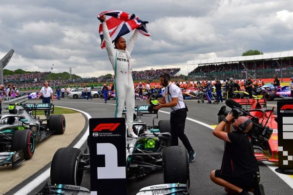 Mercedes' British driver Lewis Hamilton (C) waves the Union flag as he celebrates in parc ferme after victory in the British Formula One Grand Prix at the Silverstone motor racing circuit in Silverstone, central England, on July 14, 2019. Lewis Hamilton extended his lead at the top of the Formula One championship on Sunday after winning the British Grand Prix for a record sixth time. PHOTO | AFP