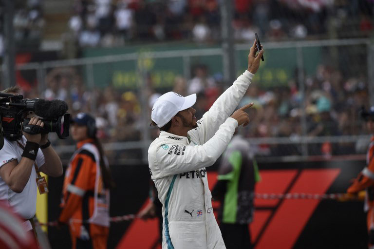 Mercedes' British driver Lewis Hamilton celebrates after winning his fifth drivers' title during the F1 Mexico Grand Prix at the Hermanos Rodriguez circuit in Mexico City on October 28, 2018. Lewis Hamilton became only the third Formula One driver in history to capture a fifth world title on Sunday as Max Verstappen won the Mexican Grand Prix. PHOTO/AFP