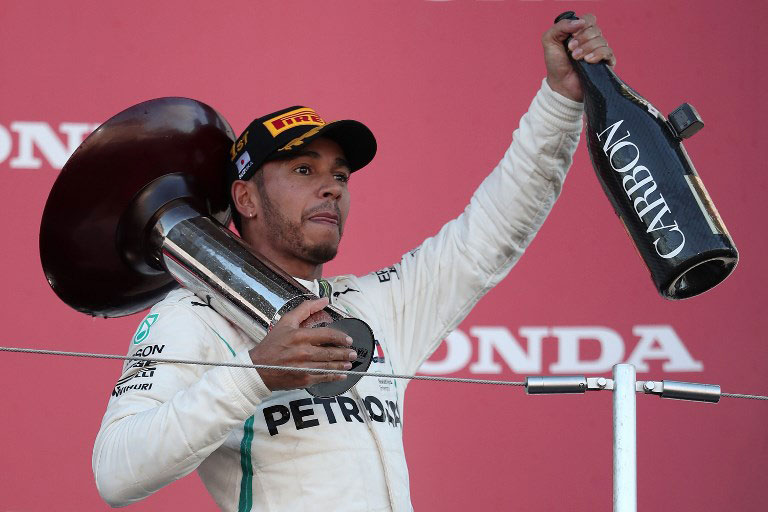 Mercedes' British driver Lewis Hamilton celebrates on the podium after his victory in the Formula One Japanese Grand Prix at Suzuka on October 7, 2018. PHOTO/AFP