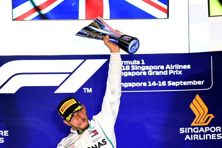 Mercedes' British driver Lewis Hamilton holds up the trophy on the podium after winning the Singapore Formula One Grand Prix at the Marina Bay Street Circuit in Singapore on September 16, 2018. PHOTO/AFP