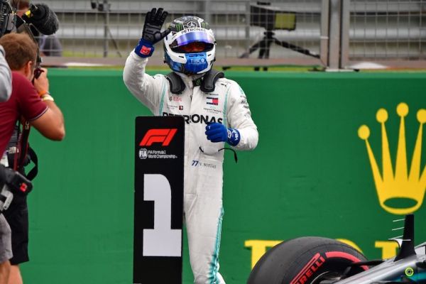 Mercedes' Finnish driver Valtteri Bottas (C) waves to supporters after securing pole position in the qualifying session at Silverstone motor racing circuit in Silverstone, central England, on July 13, 2019 for of the British Formula One Grand Prix. PHOTO/AFP