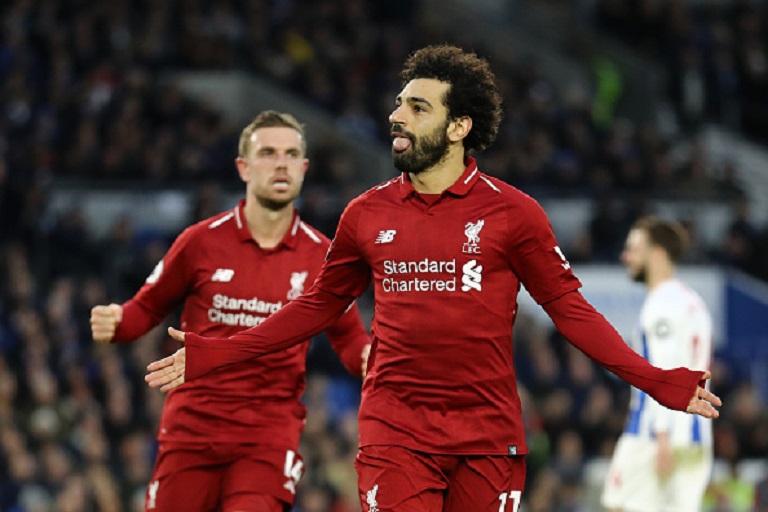 Mohamed Salah of Liverpool celebrates with team mate Jordan Henderason of Liverpool after scoring their first goal from the penalty spot during the Premier League match between Brighton & Hove Albion and Liverpool FC at American Express Community Stadium on January 12, 2019 in Brighton, United Kingdom.PHOTO/GETTY IMAGES