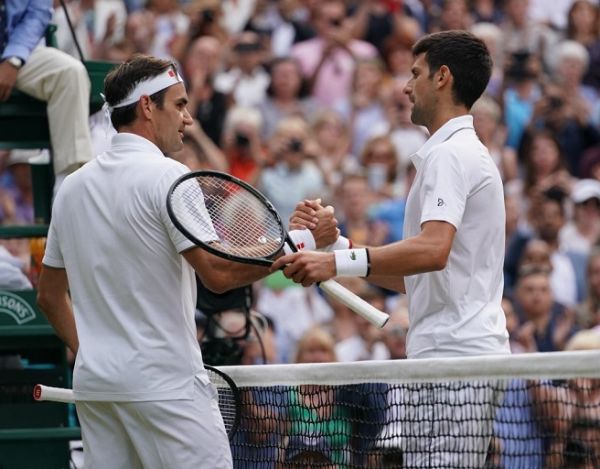 Novak Djokovic of Serbia (R) celebrates after winning the Gentlemen's singles final of the Championships, Wimbledon against Roger Federer of Switzerland at the All England Lawn Tennis and Croquet Club in London, United Kingdom on July 14, 2019. PHOTO | AFP