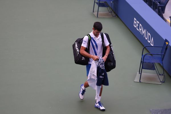 Novak Djokovic of Serbia walks off the court after being defaulted due to inadvertently striking a lineswoman with a ball hit in frustration during his Men's Singles fourth round match against Pablo Carreno Busta of Spain on Day Seven of the 2020 US Open at the USTA Billie Jean King National Tennis Center on September 6, 2020 in the Queens borough of New York City.  PHOTO | AFP