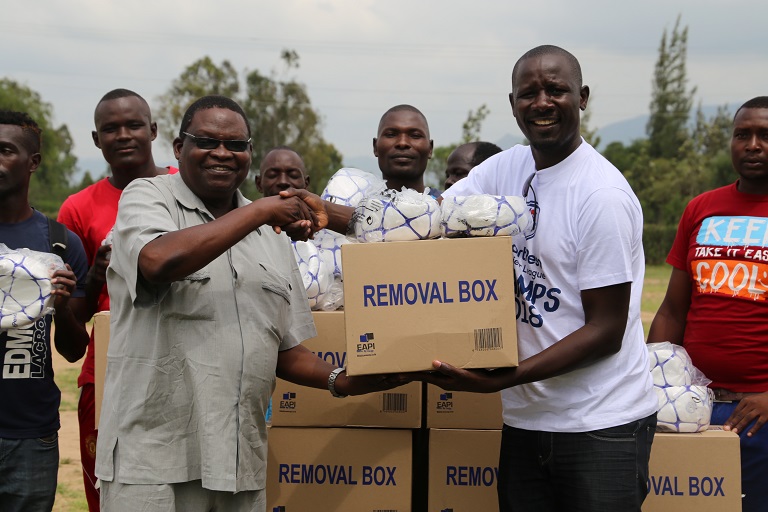 Omogi Cup Patron, Paul Waindi (Left),receives Kits For Africa boxes from SportPesa Partnerships Executive, Tom Bwana,at Aloo Gumbi High School in Kisumu on Wednesday  December 19, 2018.PHOTO/SPN