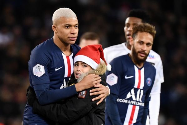 Paris Saint-Germain's French forward Kylian Mbappe hugs a young fan during the French L1 football match between Paris Saint-Germain (PSG) and Amiens at the Parc des Princes stadium in Paris on December 21, 2019. PHOTO | AFP