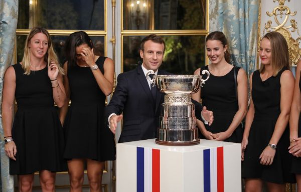 Pauline Parmentier, Caroline Garcia, Alize Cornet and Fiona Ferro of the French women tennis team abd French President Emmanuel Macron (C) pose during a reception at the Elysee presidential palace in Paris on November 12, 2019, two days after they won the Fed Cup competition. PHOTO | AFP