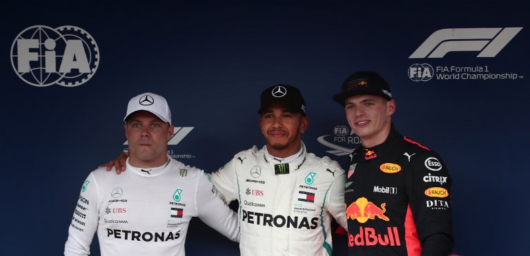 Pole position winner of the qualifying session Mercedes' British driver Lewis Hamilton (C), second pole position Mercedes' Finnish driver Valtteri Bottas (L) and third pole position Red Bull racing's Dutch driver Max Verstappen(R) pose after the qualifying session of the Formula One Japanese Grand Prix at Suzuka on October 6, 2018. PHOTO/AFP