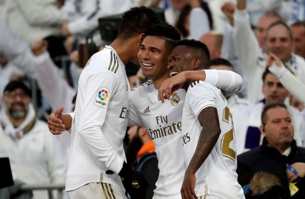 Real Madrid's Brazilian midfielder Carlos Casemiro (C) celebrates with his teammates Raphael Varane (L) and Vinicius Junior (R) after scoring his first and team's second goal with a header during the Spanish league (La Liga) football match between Real Madrid CF and Sevilla FC at the Santiago Bernabeu Stadium in Madrid, Spain on January 18, 2020. PHOTO | AFP