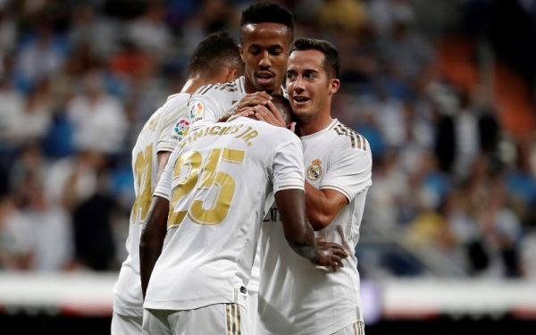 Real Madrid's Vinicius Junior (C) celebrates with his teammates Lucas Vazquez (R) and Eder Militao (L) after scoring their opening goal during a La Liga football match between Real Madrid CF and CA Osasuna at the Santiago Bernabeu Stadium in Madrid, Spain on September 25, 2019. PHOTO|AFP