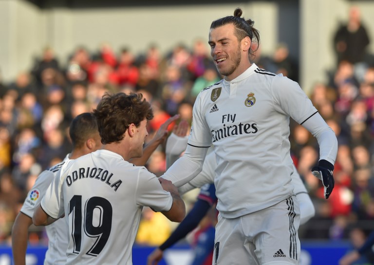 Real Madrid's Welsh forward Gareth Bale (R) is congratulated by teammate defender Alvaro Odriozola during the Spanish league football match between SD Huesca and Real Madrid CF at the El Alcoraz stadium on December 9, 2018. 