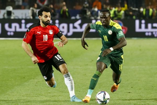 Sadio Mane of Senegal (right) runs with the ball as Mohamed Salah pursues him. PHOTO | Liverpool
