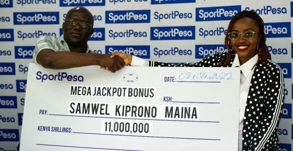Samwel Kiprono Maina gets presented his winners check after correctly predicting 16 games in the SportPesa Mega Jackpot on Monday, August 8, 2022. PHOTO | Mike Odinga | SPN