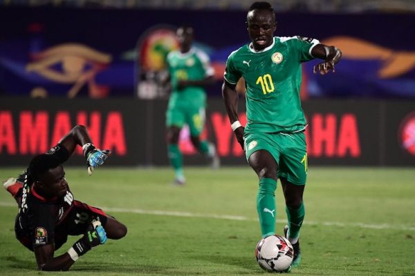 Senegal's forward Sadio Mane (R) dribbles past Benin's goalkeeper Saturnin Allagbe during the 2019 Africa Cup of Nations (CAN) quarter final football match between Senegal and Benin at the 30 June stadium in Cairo on July 9, 2019. PHOTO/AFP
