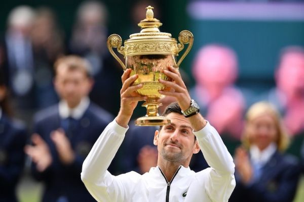 Serbia's Novak Djokovic raises the winner's trophy after beating Switzerland's Roger Federer during their men's singles final on day thirteen of the 2019 Wimbledon Championships at The All England Lawn Tennis Club in Wimbledon, southwest London, on July 14, 2019. PHOTO/AFP