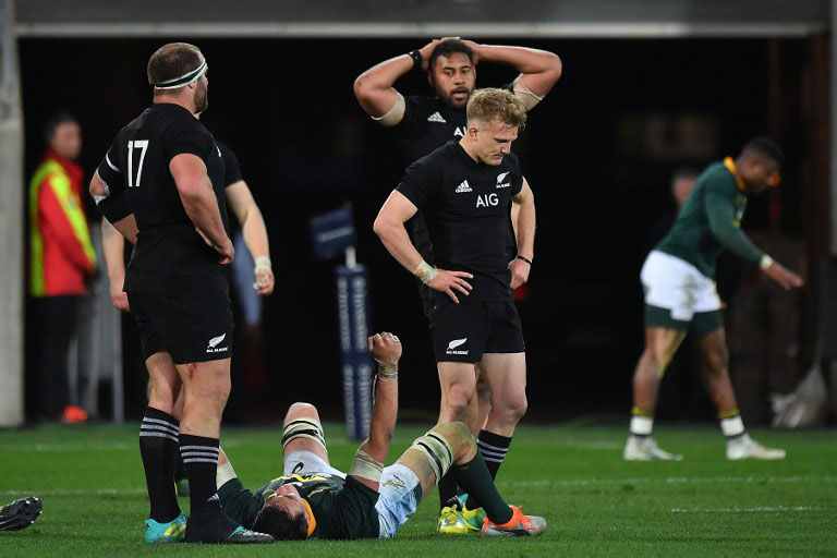 South Africa's Franco Mostert (lower) celebrates victory next to New Zealand's Damian McKenzie (R), Patrick Tuipulotu (back) and Tim Perry (L) during the Rugby Championship match between the New Zealand All Blacks and South Africa at Westpac Stadium in Wellington on September 15, 2018. PHOTO/AFP