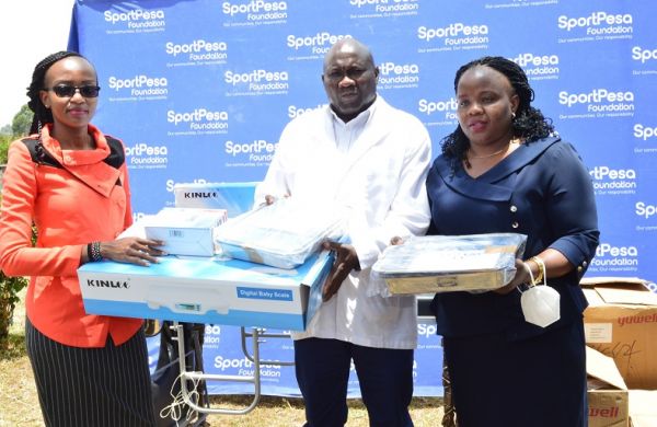 SportPesa Foundation's Project Lead Esther Kang'ethe (left) presents medical equipment to the staff at the Seregeya Dispensary in Kakamega County. PHOTO | SPN