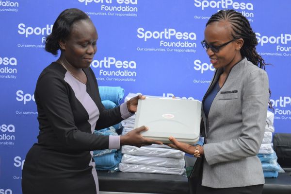 SportPesa Foundation's Project Lead Esther Kang'ethe (right) presents one of the pieces of equipment donated to the Malava Sub-County Hospital on Monday, March 28, 2022. PHOTO | SPN