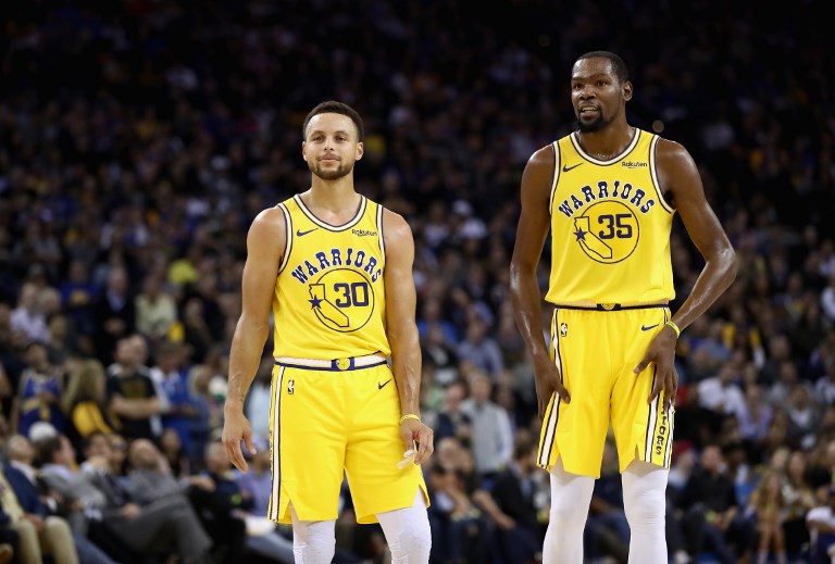 Stephen Curry #30 and Kevin Durant #35 of the Golden State Warriors stand on the court during their game against the Washington Wizards at ORACLE Arena on October 24, 2018 in Oakland, California. PHOTO/AFP