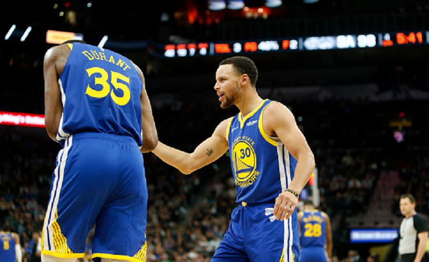 Stephen Curry #30 of the Golden State Warriors talks with Kevin Durant #35 of during game against the San Antonio Spurs at AT&T Center on March 18, 2019 in San Antonio, Texas. PHOTO/GettyImages