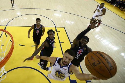 Stephen Curry of the Golden State Warriors goes up for a shot on Montrezl Harrell #5 of the LA Clippers during Game One of the first round of the 2019 NBA Western Conference Playoffs at ORACLE Arena on April 13, 2019 in Oakland, California. PHOTO/AFP