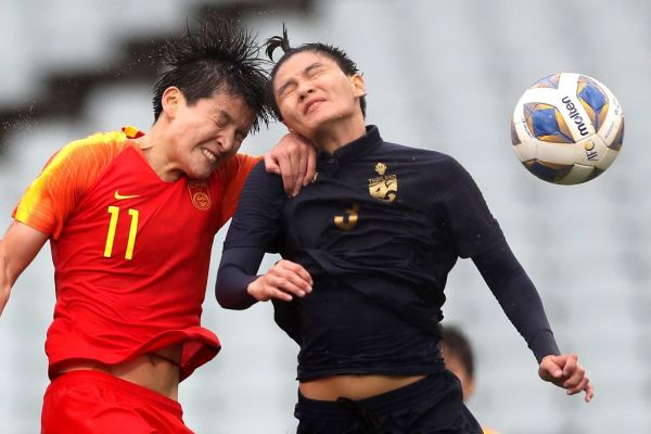 This file photo taken on February 7, 2020 shows China's Wang Shanshan (L) and Thailand's Natthakarn Chinwong competing for the ball during the women's Olympic football tournament qualifier match between China and Thailand at Campbelltown Stadium in Sydney on February 7, 2020. The coronavirus has destroyed the Tokyo Olympic dreams of some Chinese athletes and disrupted the preparations of others, forcing them to miss tournaments and train in strict isolation -- sometimes in masks. PHOTO | AFP