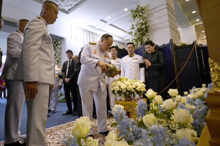 This handout photo taken and released by King Power on November 3, 2018 shows Thai Deputy Prime Minister and Defence Minister General Prawit Wongsuwan (C) pours water while Aiyawatt Srivaddhanaprabha (2nd-R) and Aimon Srivaddhanaprabha (R) son and widow of Leicester City's Thai owner and duty-free mogul, the late Vichai Srivaddhanaprabha during funeral ceremony at the the Wat Thepsirin Buddhist temple in Bangkok on November 3, 2018.PHOTO/AFP