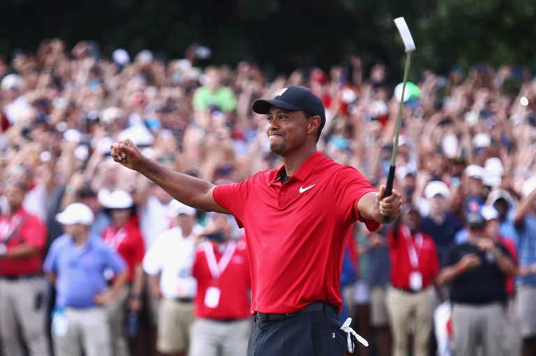 Tiger Woods of the United States celebrates making a par on the 18th green to win the TOUR Championship at East Lake Golf Club on September 23, 2018 in Atlanta, Georgia. PHOTO/AFP