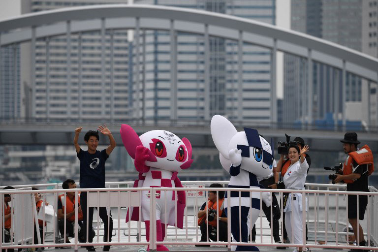 Tokyo 2020 Olympics Games mascots Miraitowa (centre 2nd R) and Someity (centre 2nd L) ride on a boat during a parade with karate practitioner Kiyo Shimizu (centre R) and para athlete Hajimu Ashida (centre L) in Tokyo on July 22, 2018. PHOTO/AFP