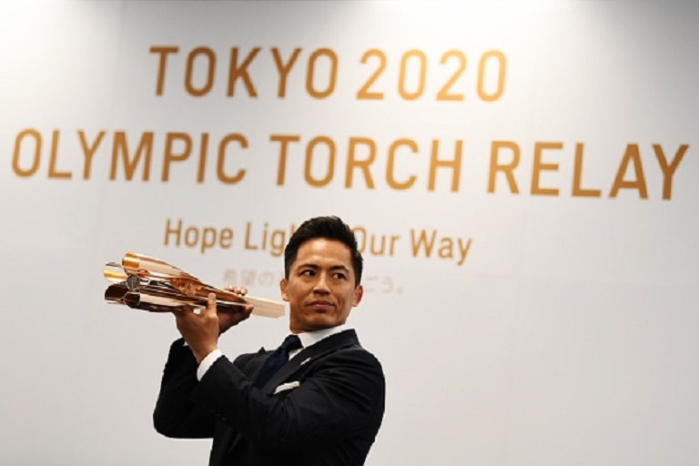 Torch Relay Ambassador Tadahiro Nomura presents the Tokyo 2020 Olympic Games torch for the torch relay in Tokyo on March 20, 2019. PHOTO/GettyImages
