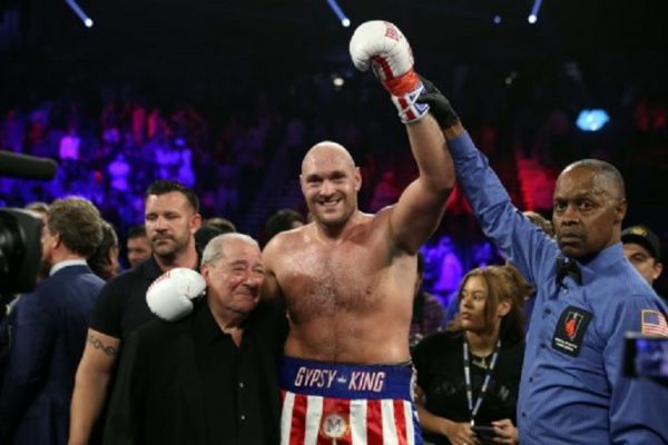 Tyson Fury (C) poses with boxing promoter Bob Arum (L) and referee Kenny Bayless after defeating Tom Schwarz during a heavyweight fight at MGM Grand Garden Arena on June 15, 2019 in Las Vegas, Nevada. PHOTO/ AFP