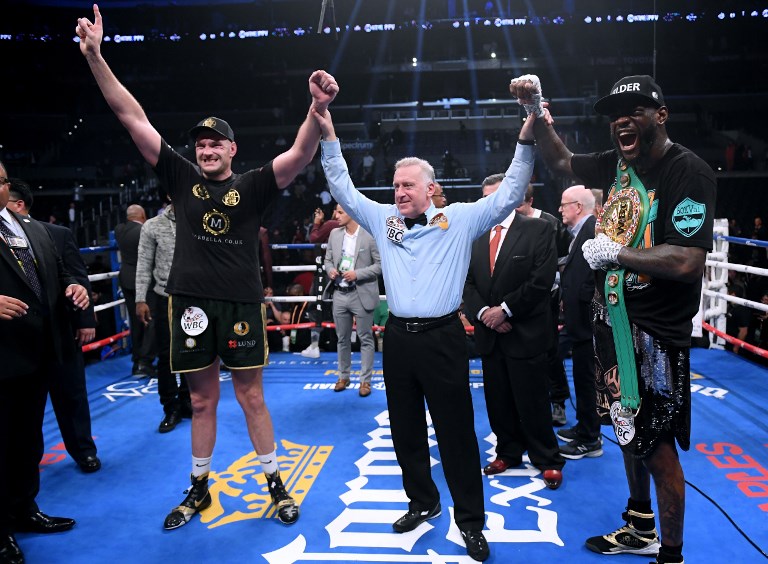 Tyson Fury and Deontay Wilder pose for a photo with referee Jack Reiss after fighting to a draw during the WBC Heavyweight Championship at Staples Center on December 1, 2018 in Los Angeles, California. PHOTO/AFP